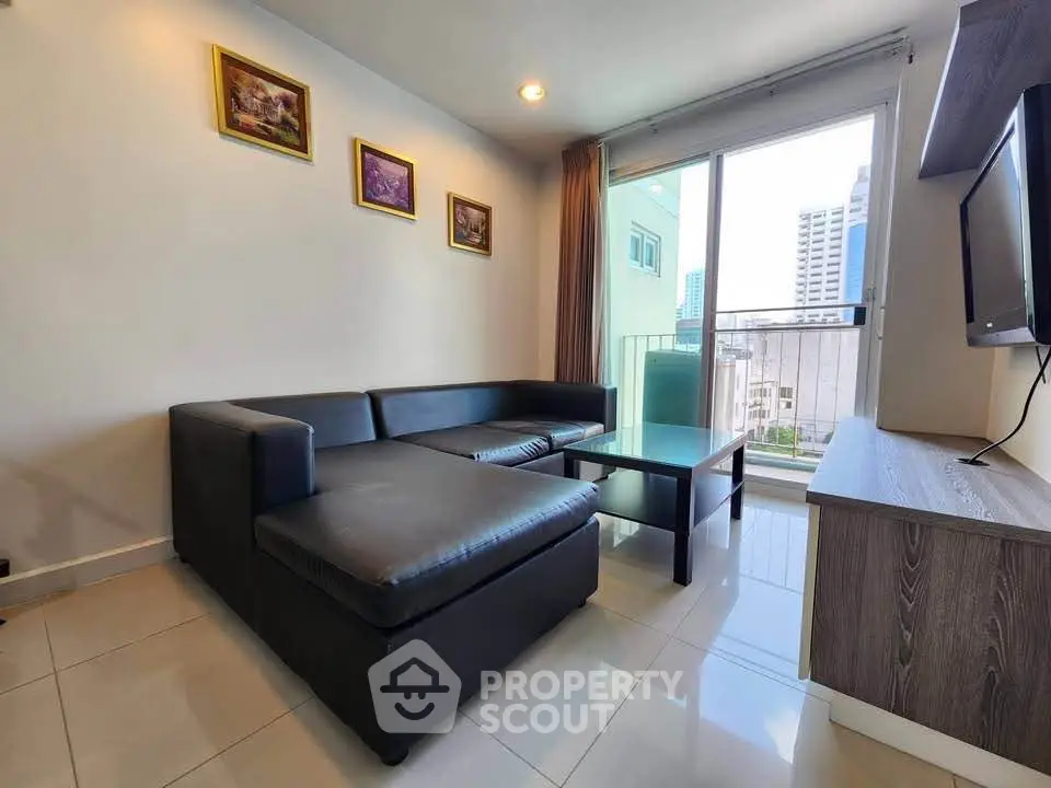 Modern living room with sleek black sofa and city view balcony