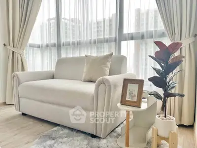 Bright living room with cozy sofa and modern decor, featuring large windows and city view.