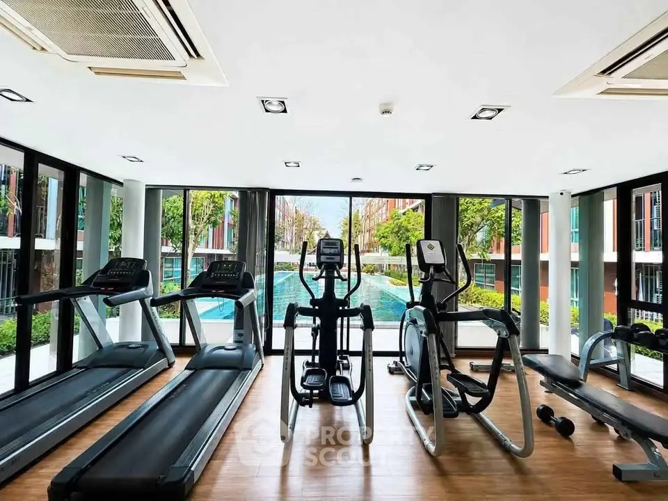 Modern gym with pool view in luxury residential complex