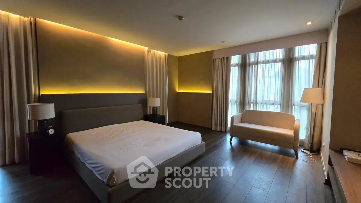 Spacious modern bedroom with large windows and elegant lighting