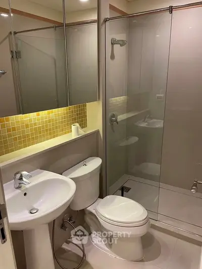 Modern bathroom with glass shower and sleek fixtures in a contemporary apartment.