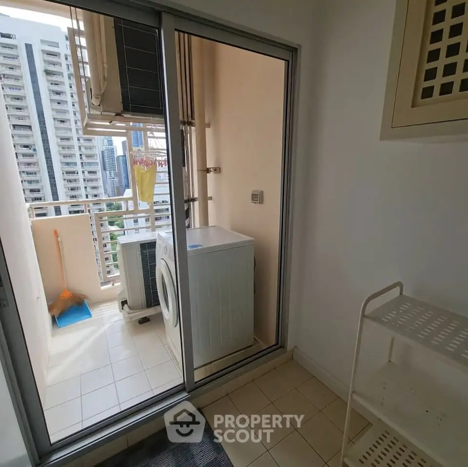 Compact balcony with washing machine and city view in modern apartment