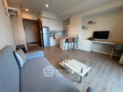 Modern open-layout living room with stylish furniture and kitchen area, perfect for urban living.
