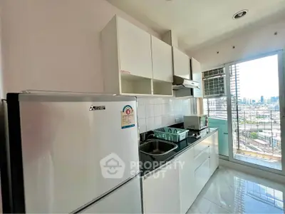 Modern kitchen with city view, featuring sleek white cabinets and stainless steel appliances.