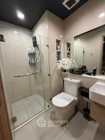 Modern bathroom with glass shower and sleek fixtures in a contemporary home.