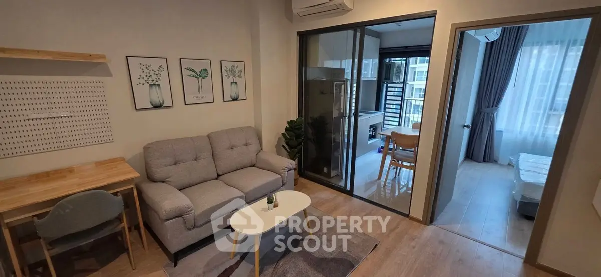 Modern apartment interior with cozy living room and glass partitioned dining area