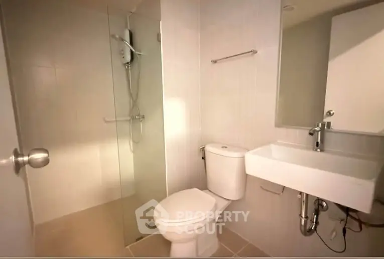 Modern bathroom with glass shower and sleek fixtures in a contemporary apartment.