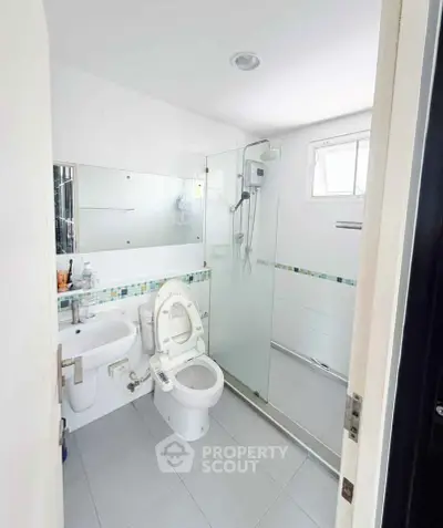 Modern bathroom with glass shower and sleek fixtures in a bright, compact space.