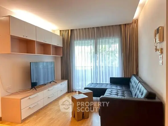 Modern living room with sleek furniture and natural light from large windows.