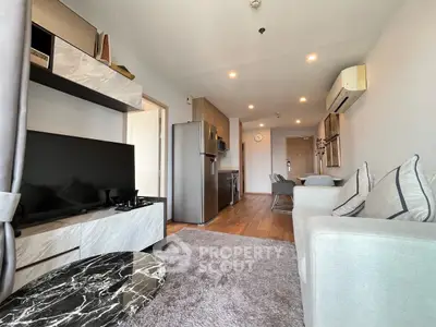 Modern living room with open kitchen, stylish decor, and cozy ambiance in a contemporary apartment.