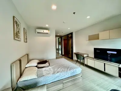 Modern bedroom with sleek design, featuring a comfortable bed, wall-mounted TV, and stylish decor.