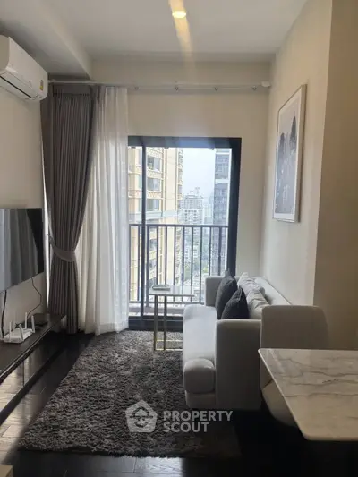 Modern living room with city view, sleek furniture, and large window for natural light.