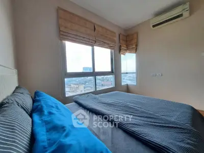 Cozy bedroom with large windows offering stunning city views and modern air conditioning.