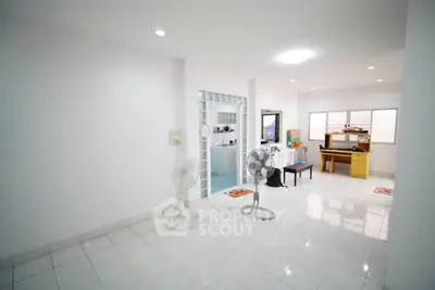 Spacious living room with tiled flooring and natural light, ideal for family gatherings.