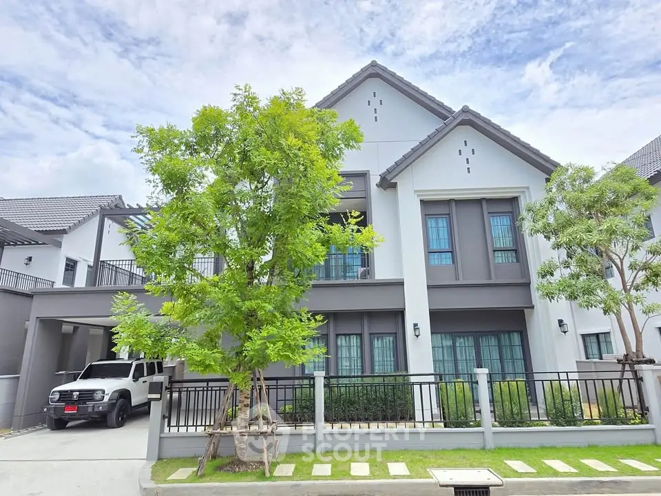 Modern two-story house with a spacious driveway and lush greenery, perfect for family living.