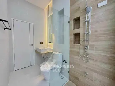 Modern bathroom with glass shower and sleek fixtures in a contemporary home.