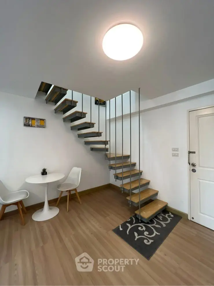 Modern interior with stylish floating staircase and cozy seating area.