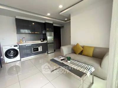 Modern open-layout living room with sleek kitchen and washing machine, perfect for urban living.