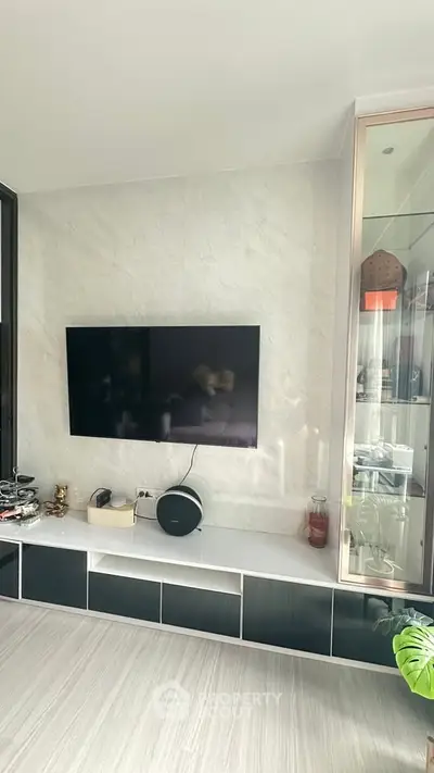 Modern living room with wall-mounted TV and sleek storage unit