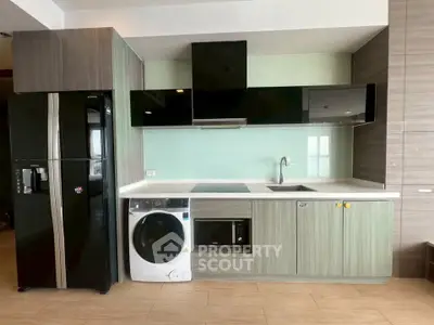 Modern kitchen with sleek appliances and stylish cabinetry in a contemporary apartment.