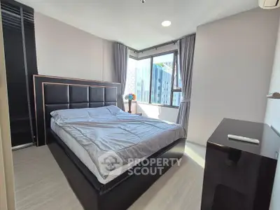 Modern bedroom with large window and stylish bed in a bright apartment