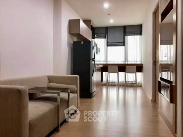 Modern apartment interior with sleek kitchen and cozy living area, featuring stylish furniture and natural light.