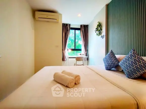 Cozy bedroom with modern decor and natural light, featuring a comfortable bed and a window view.