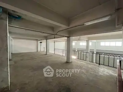 Spacious industrial loft with high ceilings and ample natural light, perfect for creative workspace or storage.