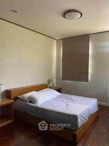 Cozy bedroom with wooden flooring and modern lighting