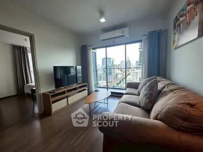 Modern living room with city view, cozy sofa, and large TV, perfect for urban living.