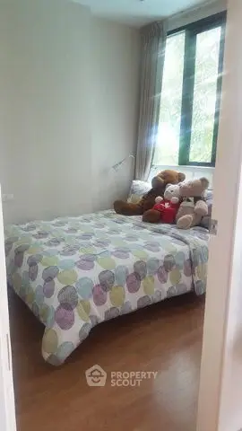 Cozy bedroom with large window and colorful bedding, perfect for relaxation.