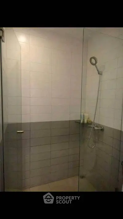 Modern bathroom with glass shower enclosure and sleek tile design.