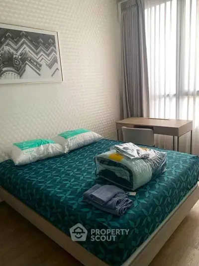 Cozy bedroom with modern decor and natural light, featuring a comfortable bed and stylish desk.