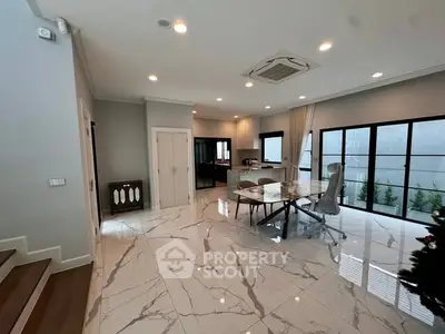 Spacious modern living room with marble flooring and open kitchen layout.