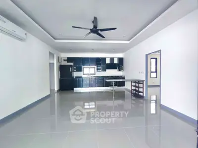 Spacious modern kitchen with sleek black cabinets and open layout in a bright apartment.