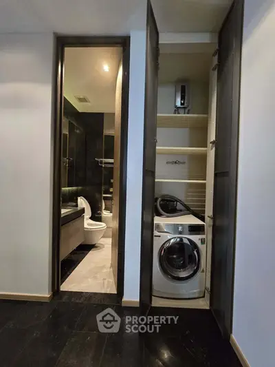 Modern bathroom with washing machine in sleek storage closet