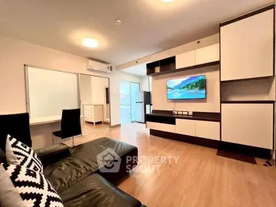 Modern living room with sleek furniture and wall-mounted TV, featuring wooden flooring and stylish decor.