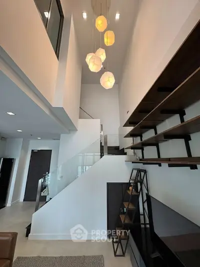 Modern living room with high ceiling and stylish lighting fixtures