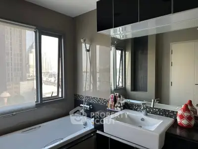 Modern bathroom with city view, featuring sleek fixtures and a spacious bathtub.