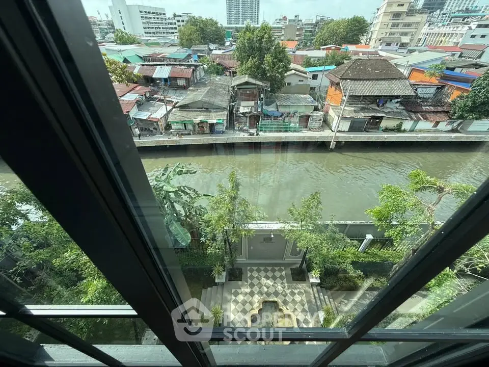 Stunning urban view from high-rise window overlooking river and cityscape, perfect for modern living.