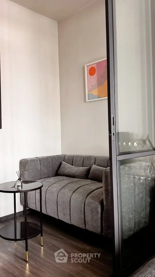 Stylish modern living room with plush gray sofa and sleek side table, perfect for urban living.