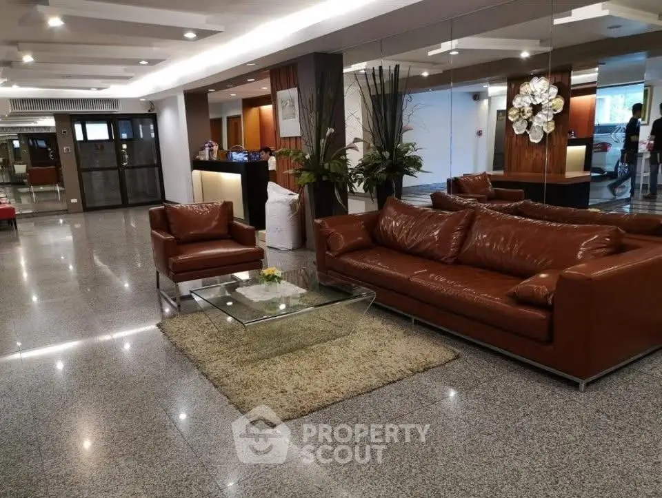 Luxurious lobby with elegant leather sofas and modern decor in a high-end residential building.