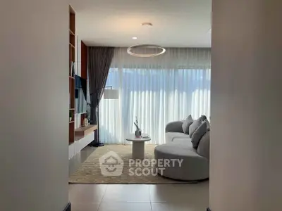 Modern living room with elegant circular sofa and floor-to-ceiling windows