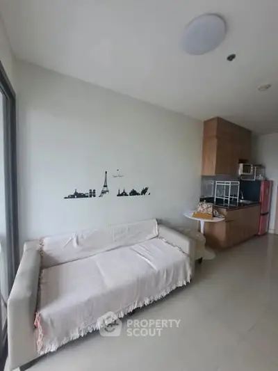 Modern living room with cozy sofa and compact kitchen area, perfect for urban living.