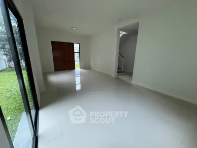 Spacious modern living room with large windows and garden view, perfect for family gatherings.
