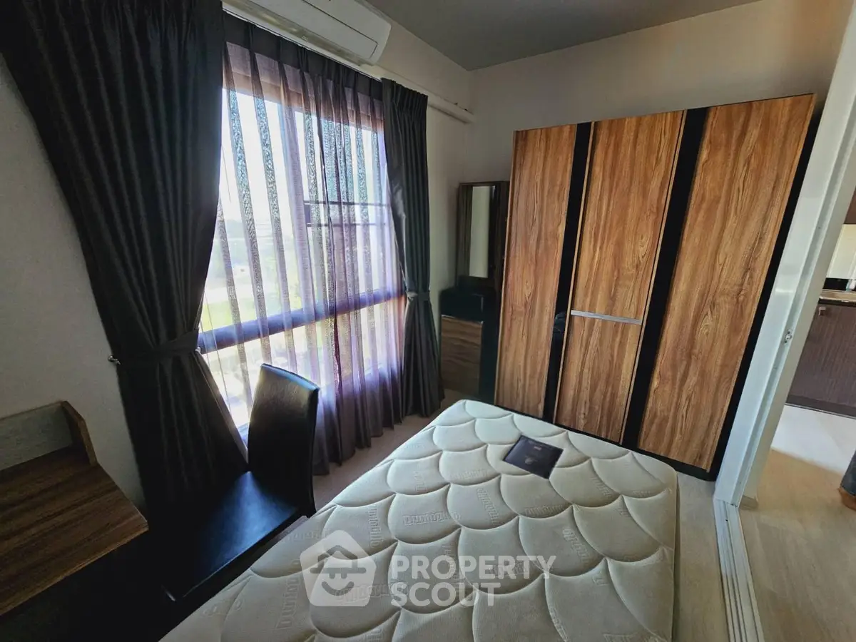Cozy bedroom with modern wooden wardrobe and large window with curtains