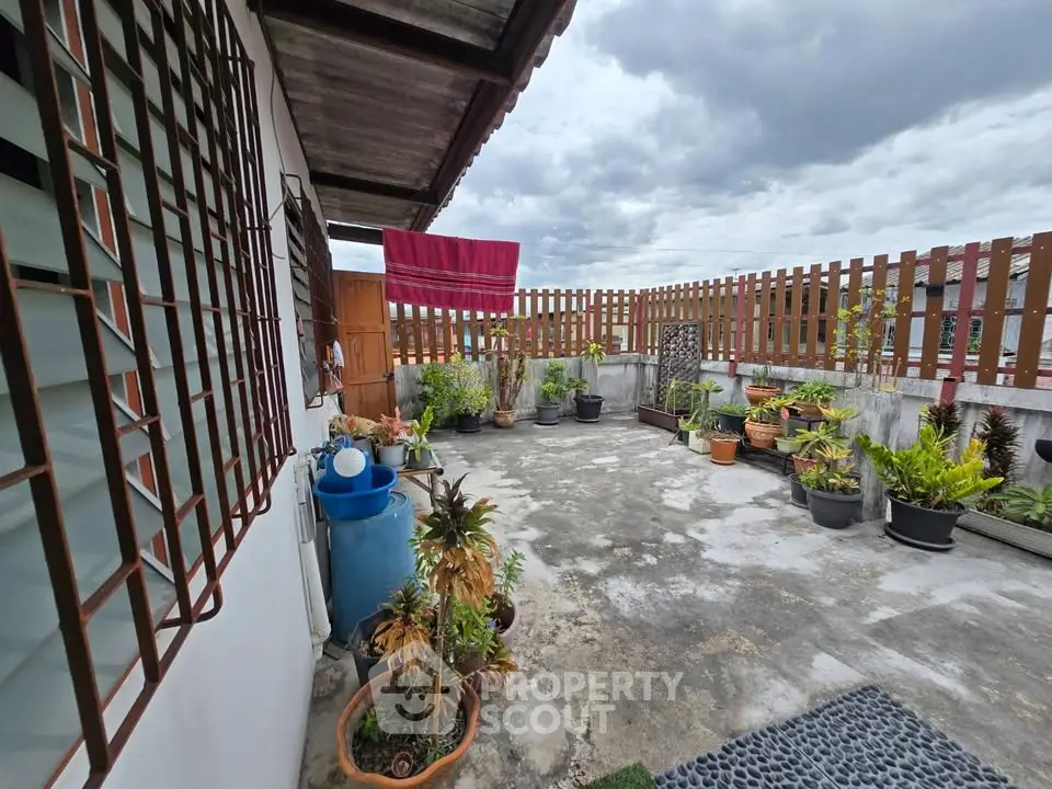 Spacious rooftop terrace with potted plants and scenic views, perfect for outdoor relaxation.