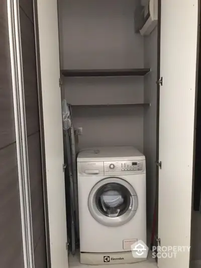 Compact laundry space with modern washing machine tucked in a built-in closet, offering efficient use of space in a stylish home.