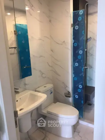 Modern bathroom with sleek design and marble walls in a contemporary apartment.