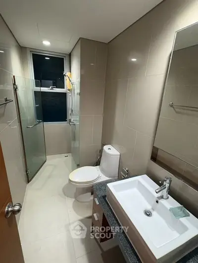 Modern bathroom with sleek fixtures and glass shower enclosure